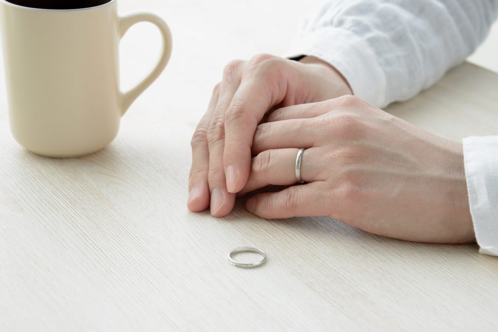 結婚指輪を外した女性の手先とコーヒー